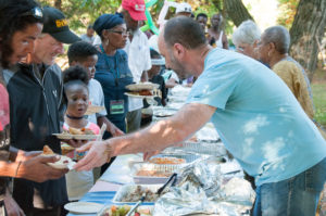People serving food at a picnic