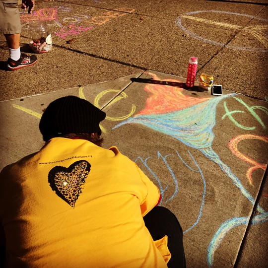 Allegheny member Laura Conkle draws a chalice on sidewalk with chalk